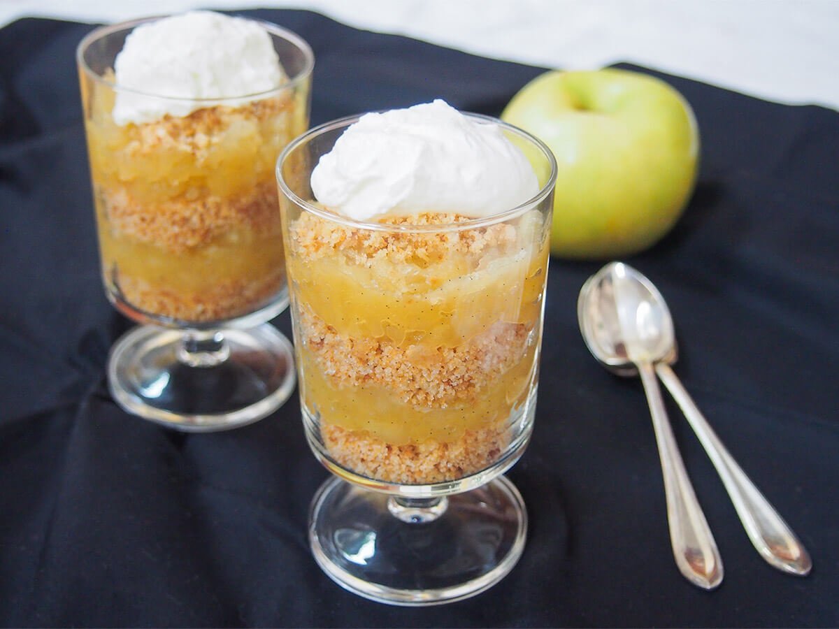 two servings of æblekage Danish apple trifle two glasses of æblekage Danish apple trifle with spoons to side