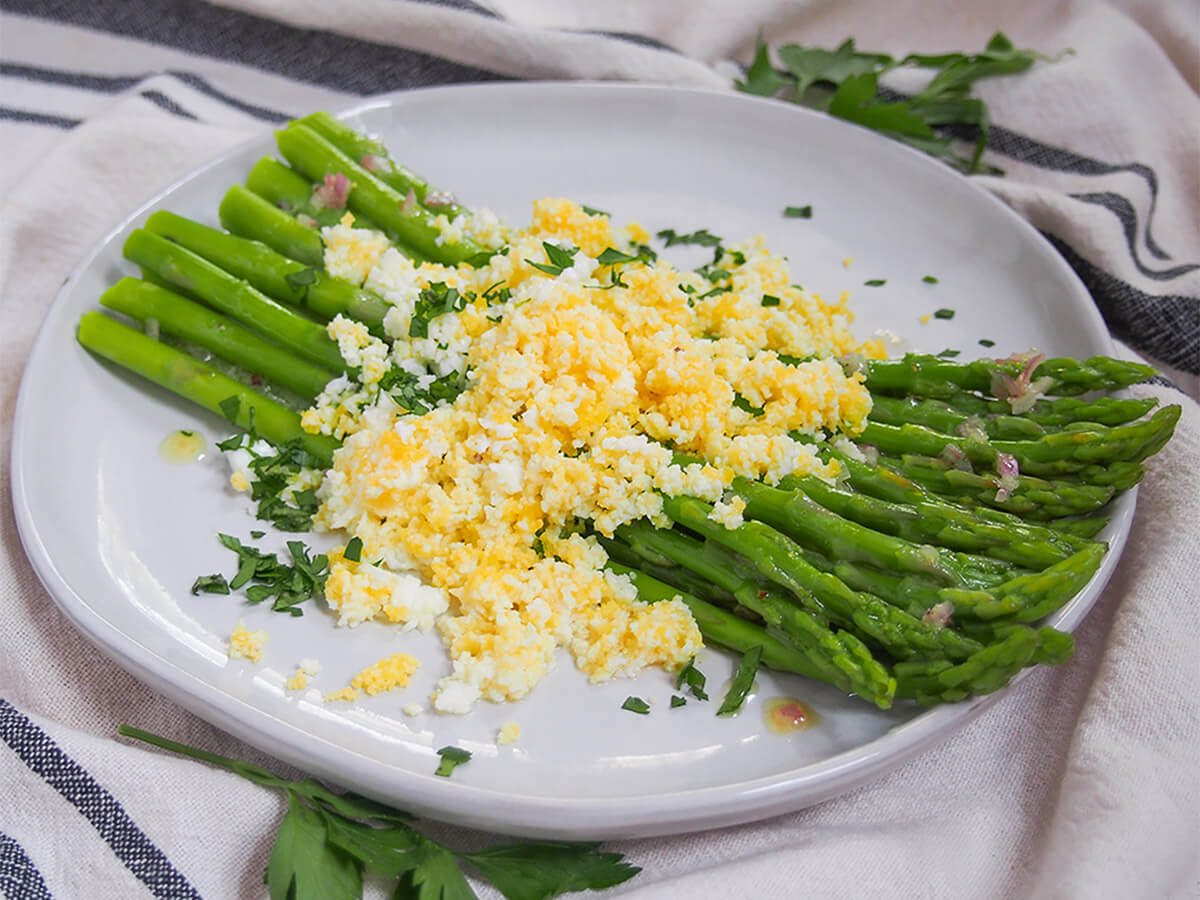 Asparagus mimosa is a simple, bright and tasty dish that's packed with spring goodness. It's great as a side dish, or can even be a light lunch in itself. A great way to use asparagus while it's in season. side view of plate of asparagus mimosa