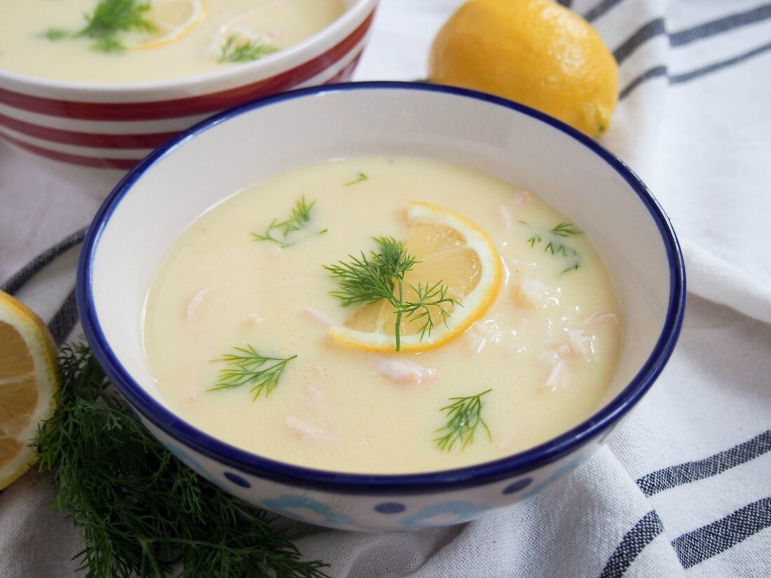 Avgolemono soup is the Greek answer to chicken noodle soup, but I've got to say - I think they win. Not only is it comfortingly warming, it has a lovely lemony undertone. Perfect for a cold day. Bowl of avgolemono soup with lemon behind bowl