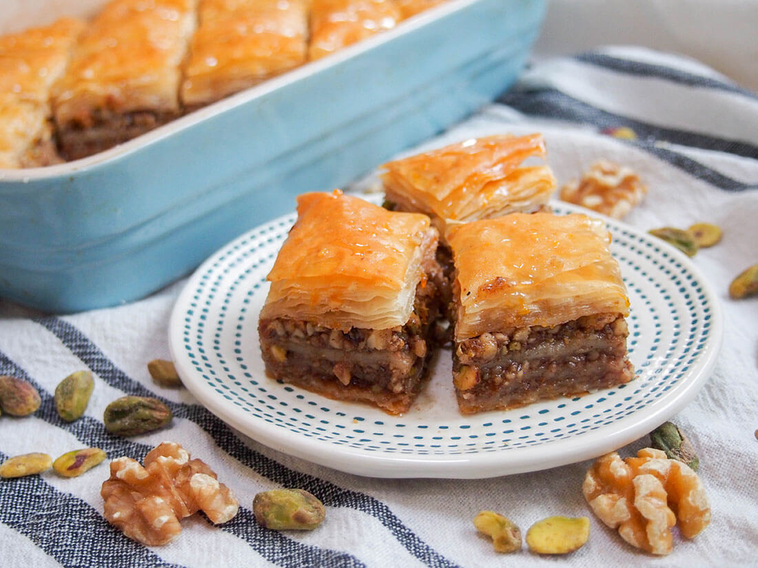 Baklava is such a classic sweet treat enjoyed in Greece, Turkey and across the broader Eastern Med. The combination of sticky, crisp pastry and nuts is addictively good! This baklava recipe will guide you through making a smaller batch, perfect for when you don't need a huge quantity. baklava pieces on small plate