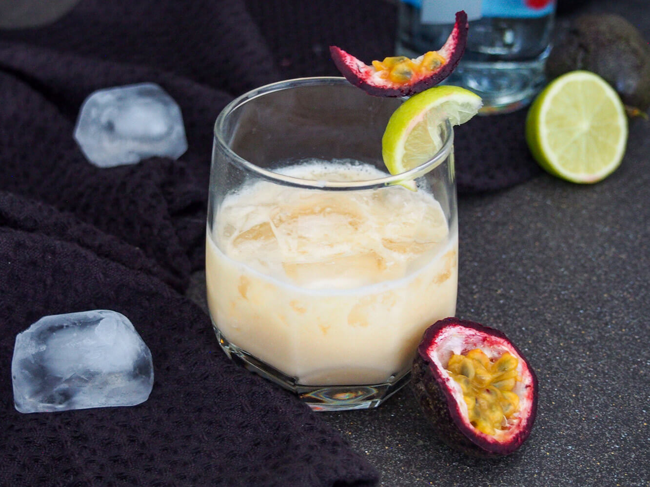 A batida is a popular cachaça cocktail in Brazil that's strangely less well known elsewhere. It's easy to make, sweet-tart and refreshing and perfect for sipping on a warm day. glass of batida with half passion fruit to side and lime behind