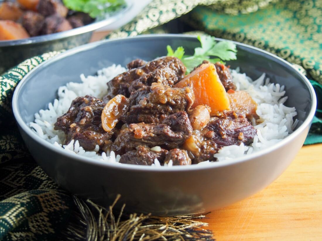 This beef massaman curry may not have the spicy heat of some other curries, but it is packed with fabulously aromatic flavors. The slow cooked beef is meltingly tender in this delicious, comforting meal. Bowl of beef massaman curry served over rice