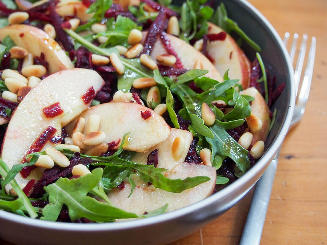 beet apple salad beet apple salad topped with toasted pine nuts with fork to side of bowl