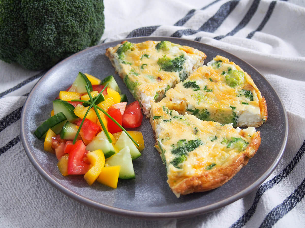 This broccoli goat cheese frittata is easy to make with a tasty mix of broccoli, soft goat cheese and sweet onion. It's perfect as part of brunch, paired with salad for a light lunch or pack it for a picnic. slices of broccoli goat cheese frittata with salad to side