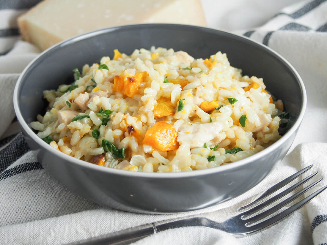 This butternut squash risotto combines roasted squash with chicken and arugula for a smooth, warming and tasty fall/winter meal (and a great way to use leftovers!) bowl of butternut squash risotto with chicken with fork in front