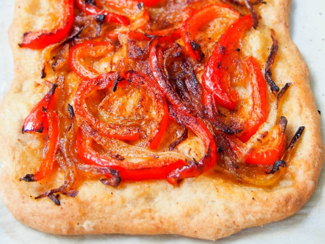 Catalan coca is a kind of a Spanish pizza or flatbread, but with some key differences - while toppings vary, most have no sauce and no cheese. But don't let that put you off, this is one delicious slice, and this simple pepper and onion version is a favorite. bottom part of Catalan coca Spanish pizza