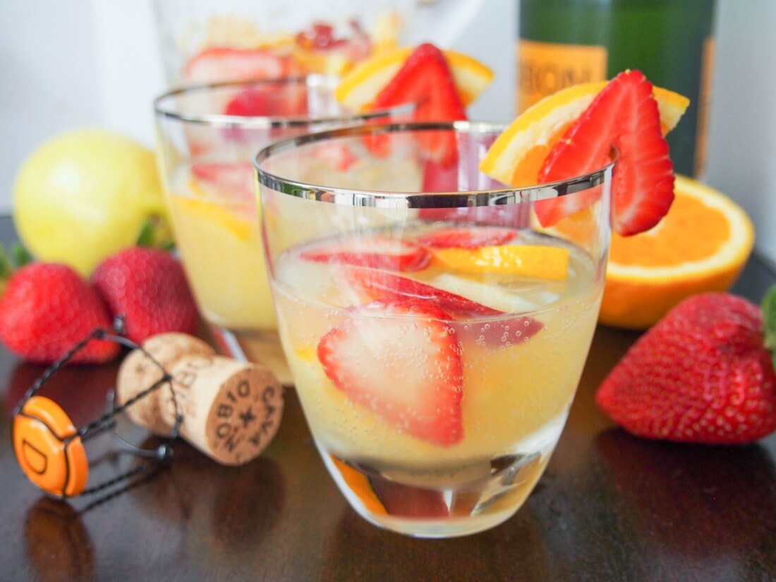 cava sangria is a light and flavorful sangria variation that's perfect for summer and special occasions two glasses of cava sangria with fruit and cork around glasses