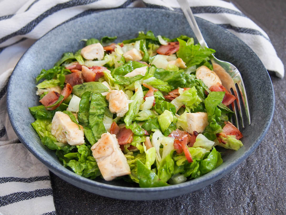 This chicken bacon salad doesn't have a lot of ingredients but it's packed with delicious flavor, all brought together with a tasty honey mustard vinaigrette. It makes a great light lunch or add in a few extras for a fuller meal. bowl of chicken and bacon salad viewed from front with fork inside bowl to one side