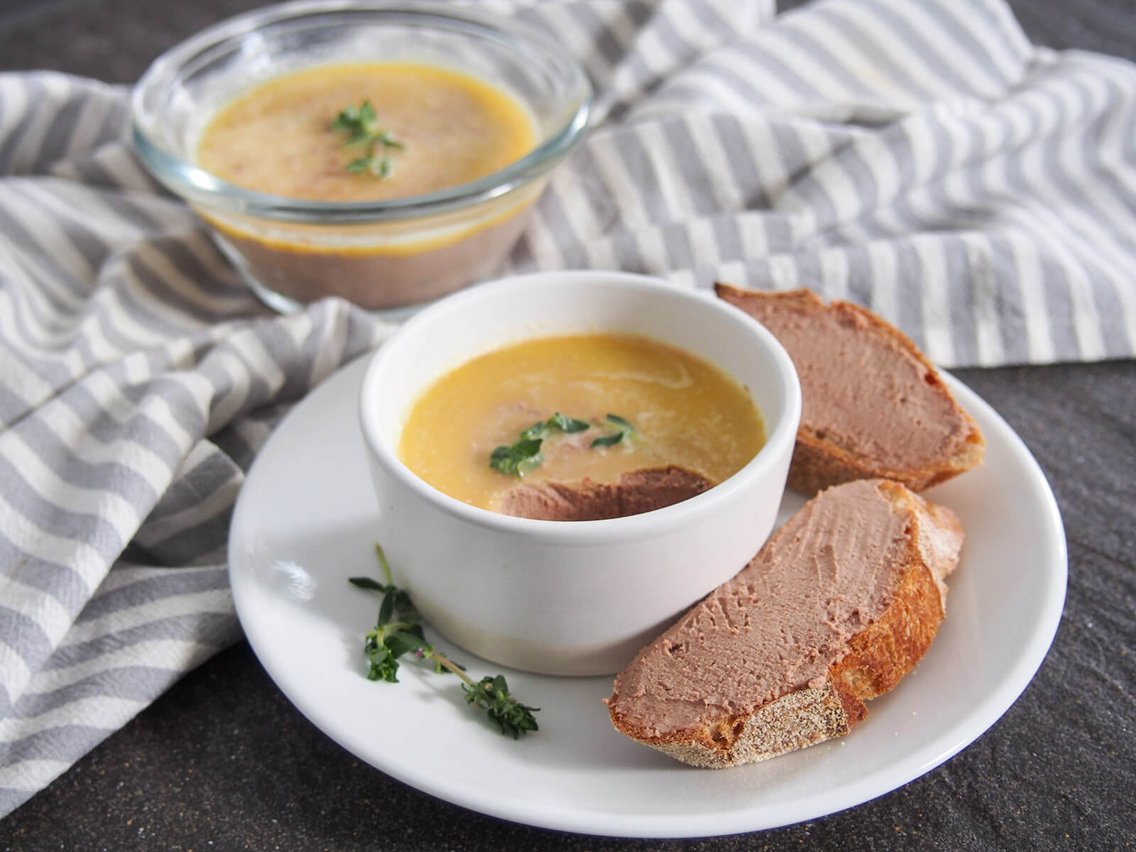 Chicken liver pate is a classic as an appetizer or on charcuterie boards, with a wonderfully smooth and gently rich flavor. It's also really easy to make and is perfect to make ahead for entertaining. dish of chicken liver pate with some spread on slices of baguette to side and second dish behind