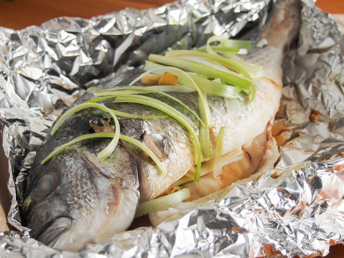 Steamed whole fish is a classic Chinese way to prepare it. But don't worry about not having a large steamer, you can make this delicious Chinese oven steamed fish with plain old foil. The result is wonderfully tender fish perfect any time. Chinese oven steamed fish in foil with head to front