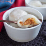 peanut filling showing on Chinese sweet dumplings - tangyuan - resting on bowl