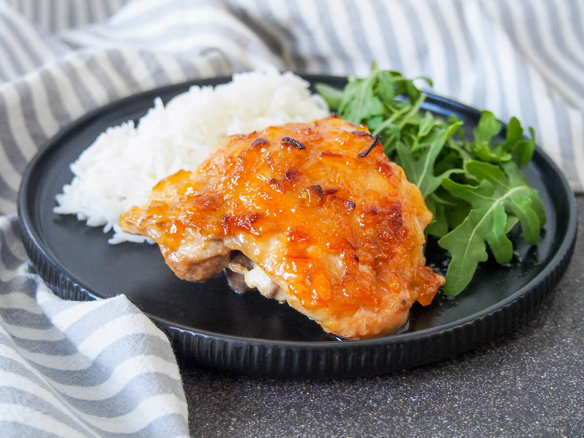This South African chutney chicken takes mere minutes to prepare and the result is tasty, sticky roasted chicken, perfect for a quick and easy meal. chutney chicken with rice and salad behind