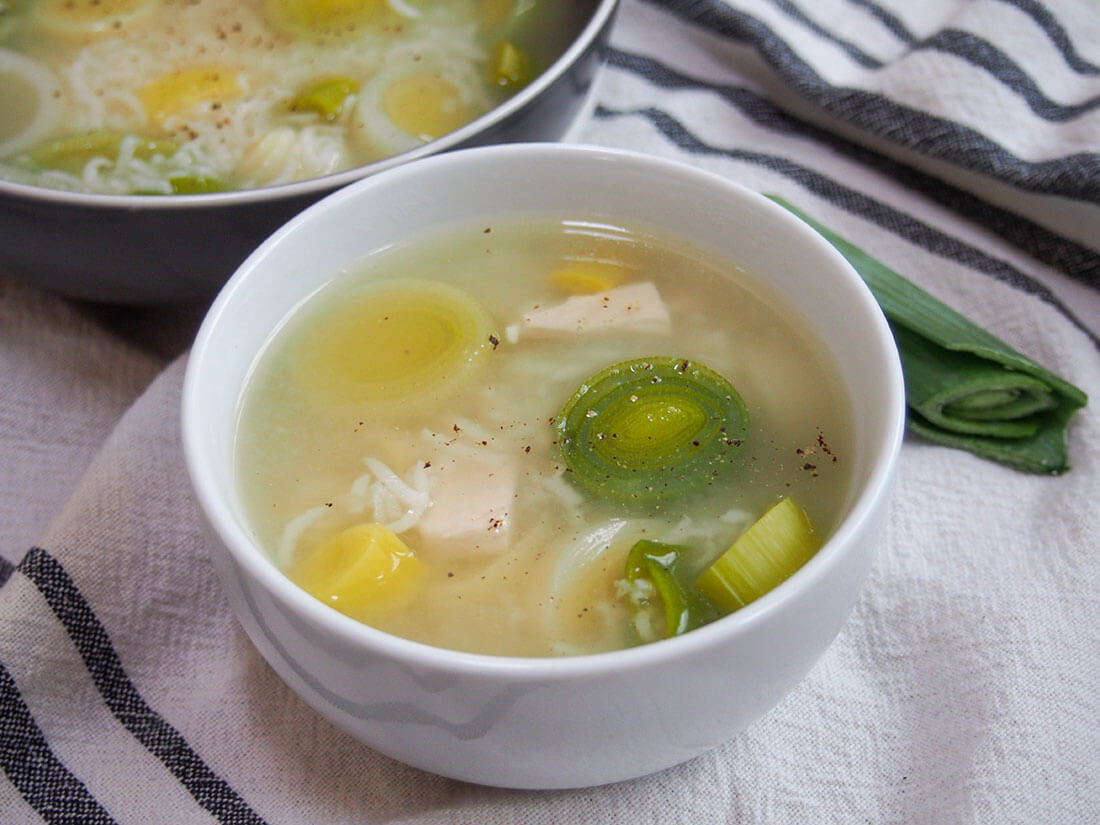 Cock-a-leekie soup is a simple Scottish soup made with chicken and leeks. Made with just a few ingredients, it's deliciously comforting and perfect for a cold day. Cock-a-leekie soup in white bowl