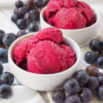 bowls of Concord grape sorbet with grapes to either side.