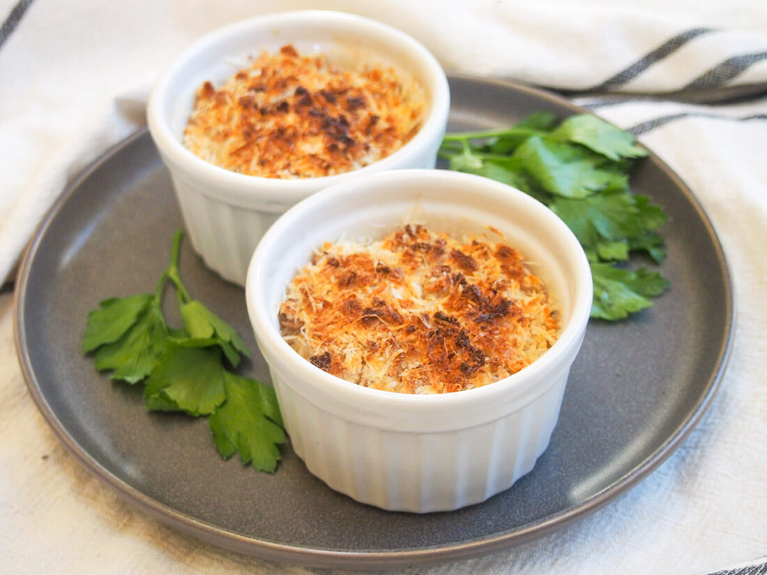 Coquille St Jacques is a scallop gratin with the scallops wrapped in a cream & wine sauce with a crisp topping. Make someone feel special and make it soon! two dishes of Coquille St Jacques (scallop gratin)