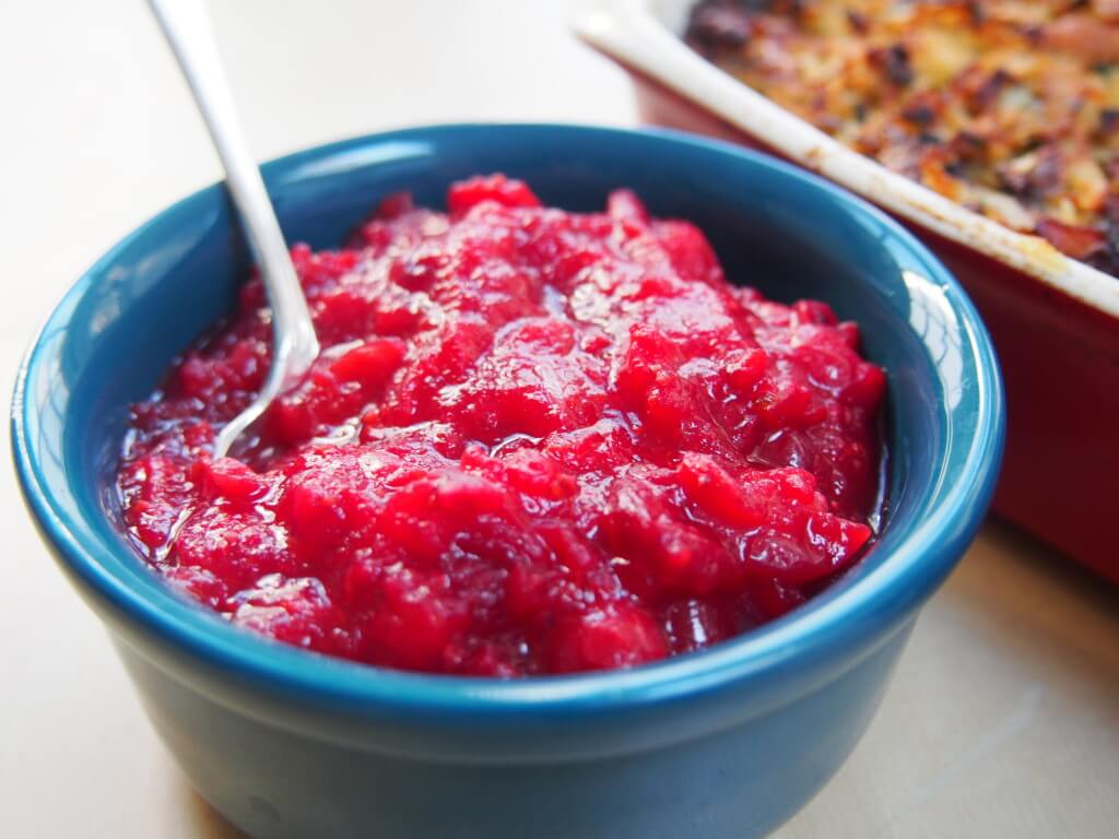 This cranberry sauce recipe uses only 3 ingredients and is mainly sweetened with orange juice. As a result, it's lower in sugar with a lovely zesty flavor. So worth the effort to make yourself. bowl of cranberry sauce with spoon in it