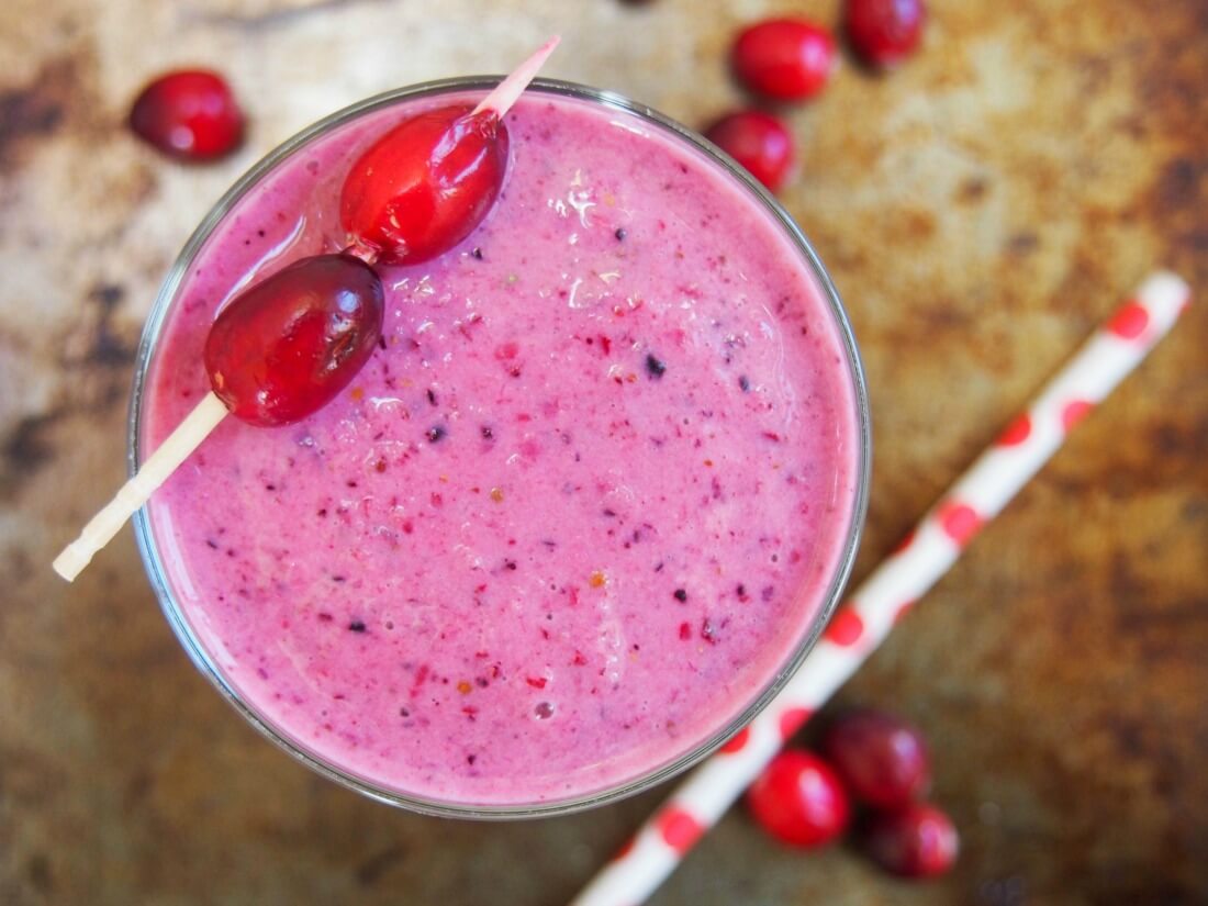 Easy to make, and with 2 kinds of superfood berries, this cranberry smoothie is a refreshing, colorful glass. Plus, no need to hunt down any unusual ingredients. cranberry smoothie viewed from overhead with straw to side and cranberries on top of glass