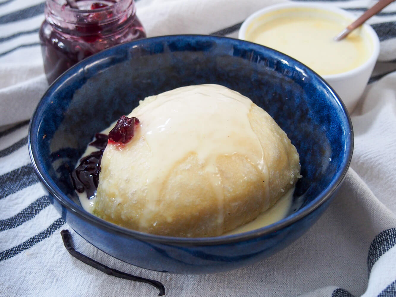 Dampfnudel is a steamed German sweet dumpling that's almost like a sweet bread, served with a luscious vanilla custard and often fruit compote. It's hearty but wonderfully comforting and delicious. dampfnudel served with vanilla sauce over top and jam to side