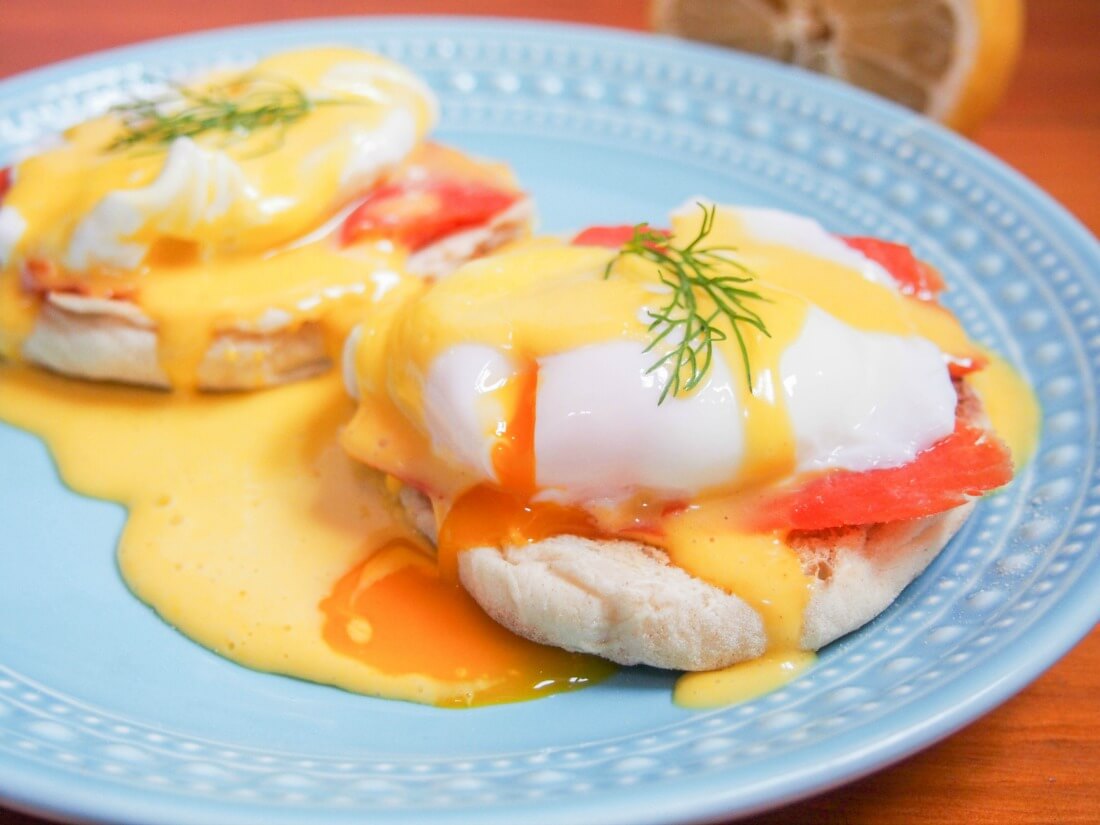 Eggs Royale is a variation of eggs Benedict made with smoked salmon and is a big favorite in our house. Delicious flavors, easy to make it's the kind of brunch that will make anyone feel special. Eggs Royale (smoked salmon eggs Benedict) on plate with egg yolk cut and oozing into sauce