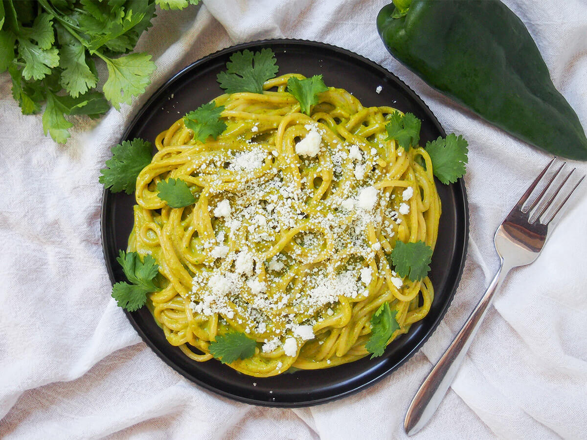 plate of espagueti verde Mexican green spaghetti plate of espagueti verde Mexican green spaghetti with fork to side