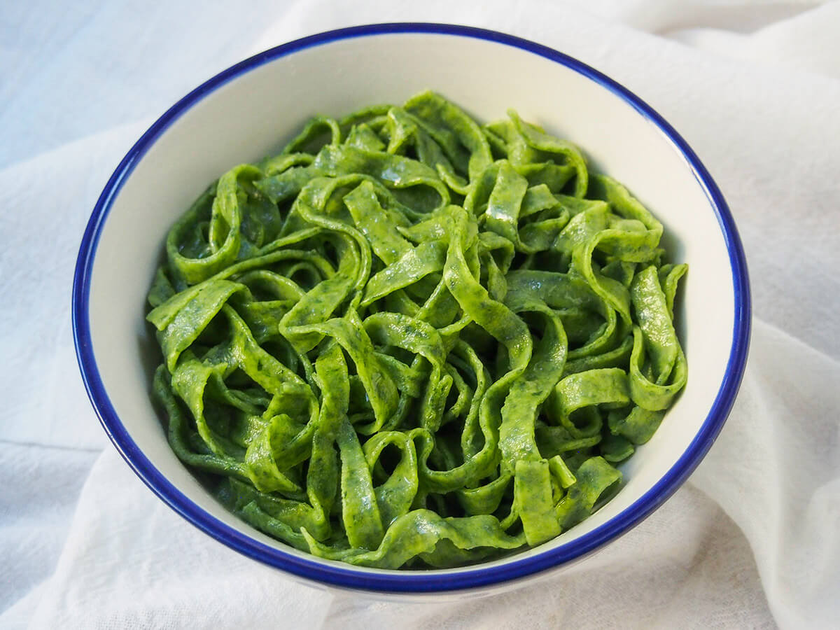 Making your own fresh spinach pasta is easier than you might think and the result is so delicious. Try with a simple sauce/browned butter for a tasty meal. white bowl filled with fresh spinach pasta
