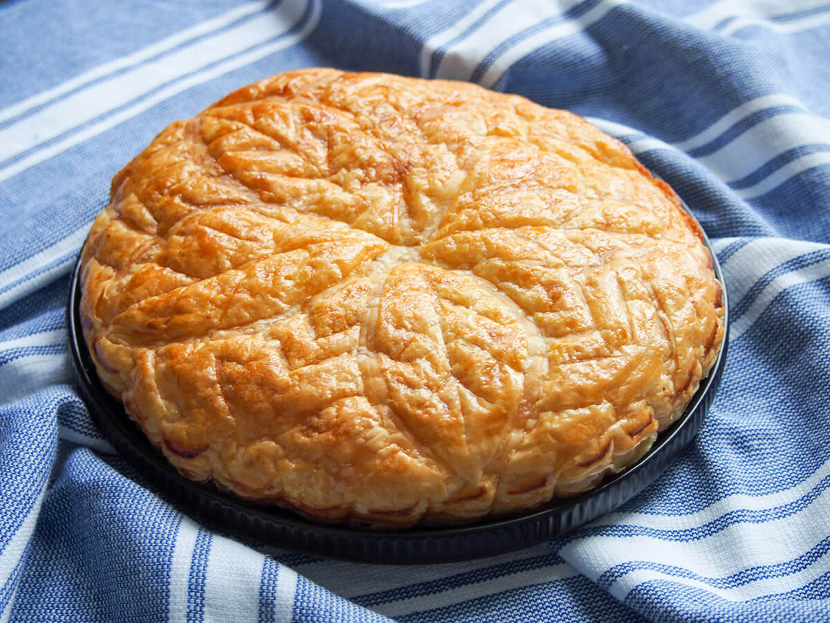 Galette des rois is the traditional French Epiphany cake (king cake) but this tasty and easy combination of puff pastry & almond cream filling is perfect any time. galette des bois, French king cake, on plate
