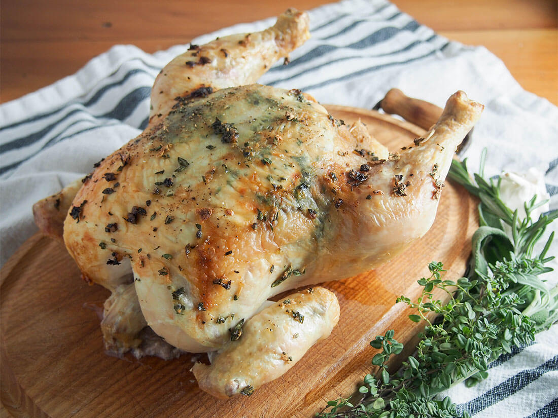 garlic herb roasted chicken is that bit more special than your plain roasted chicken with minimal extra effort garlic herb roasted chicken on board with fresh herbs to side