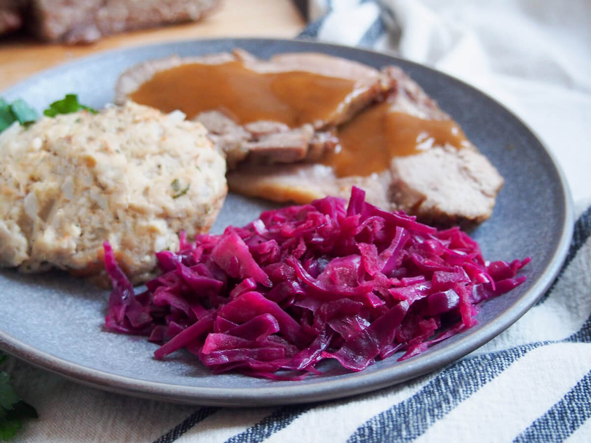 This braised red cabbage with apples (Rotkohl or Blaukraut) is a classic Germanic side that's a delicious mix of sweet-sour flavors with a mildly aromatic spice. Easy to make and comfortingly tasty. German braised red cabbage in front of pork with sauce and dumpling to side