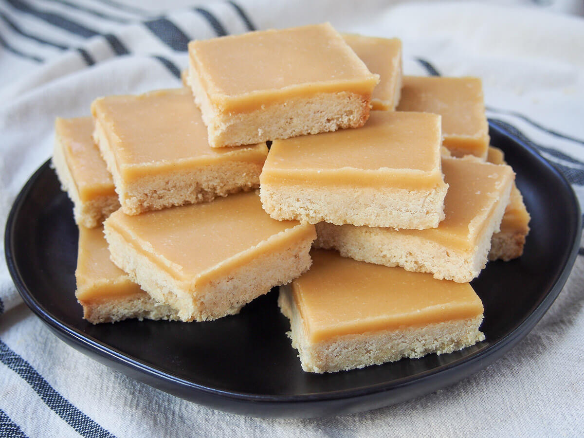 stack of ginger crunch slice - New Zealand cookie bars plate with squares of ginger crunch slice stacked on it