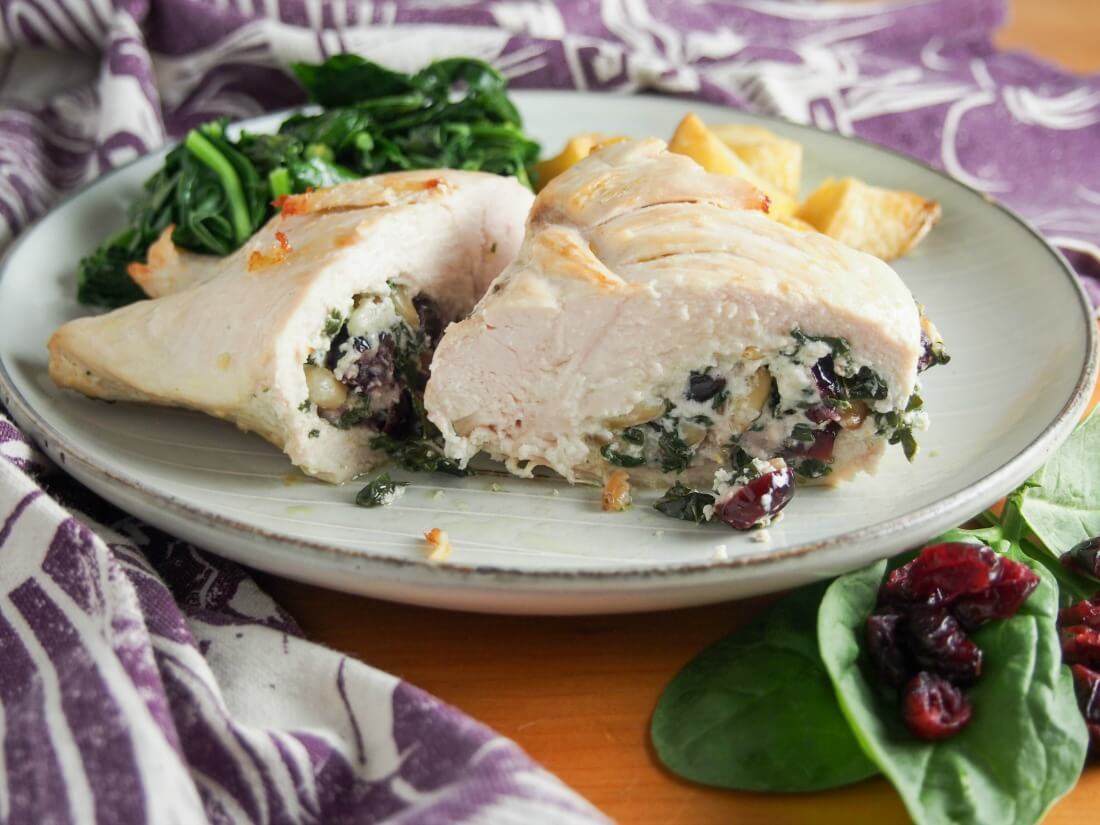Goat cheese stuffed chicken with spinach and cranberries Goat cheese stuffed chicken with spinach and cranberries on plate with chicken cut open to see filling