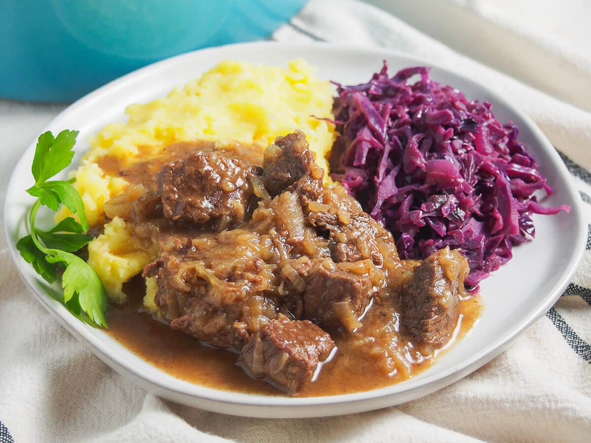 plate with hachee, Dutch beef and onion stew plate of hachee Dutch beef stew served with red cabbage and mashed potato behind.