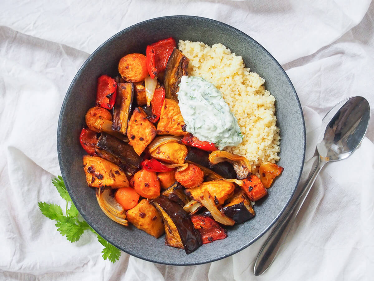 harissa roasted vegetables bowl of harissa roasted vegetables with spoon to side.