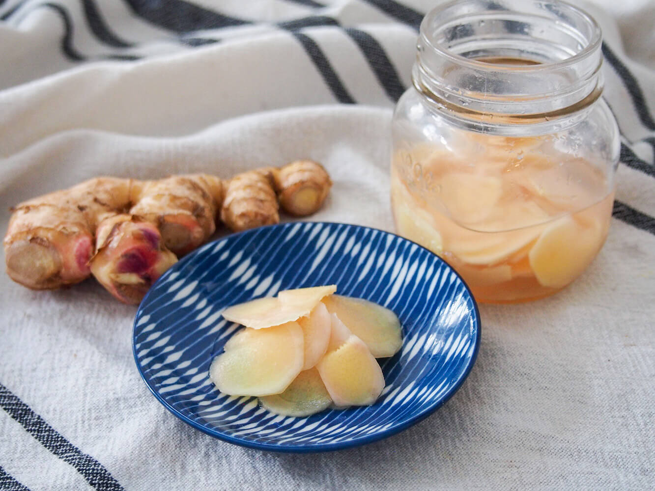 Japanese pickled ginger (gari) is an essential side for sushi and much easier than you might think to make at home. This recipe makes a small batch that's easy to use. Japanese pickled ginger on small plate with additional in jar to side