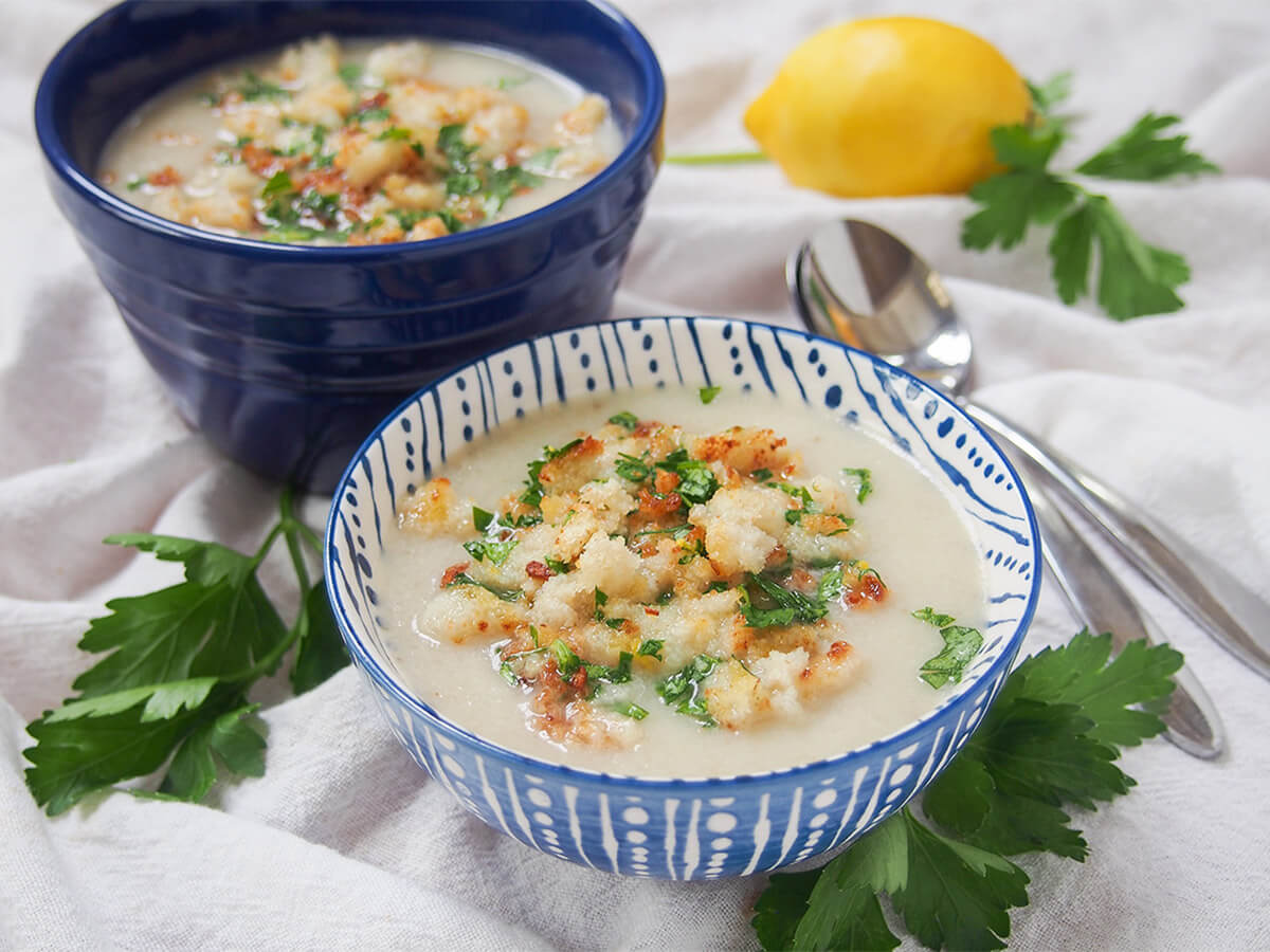 Jerusalem artichoke soup (sunchoke soup) is easy to make, flavorful and comforting. The seasoned crumb topping adds a lovely extra flavor & texture. Great for lunch or as an appetizer. bowl of Jerusalem artichoke soup with second bowl and. lemon behind