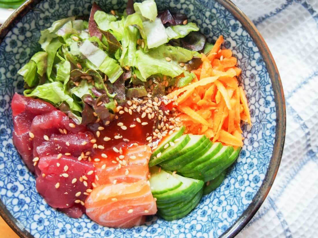 This Korean sashimi rice bowl is so easy to put together and is a delicious combination of tender sashimi, crunchy salad, rice & a sweet-spicy sauce. It makes a great, easy meal whether for dinner or lunch. Korean sashimi rice bowl with sashimi to bottom and salad top and side