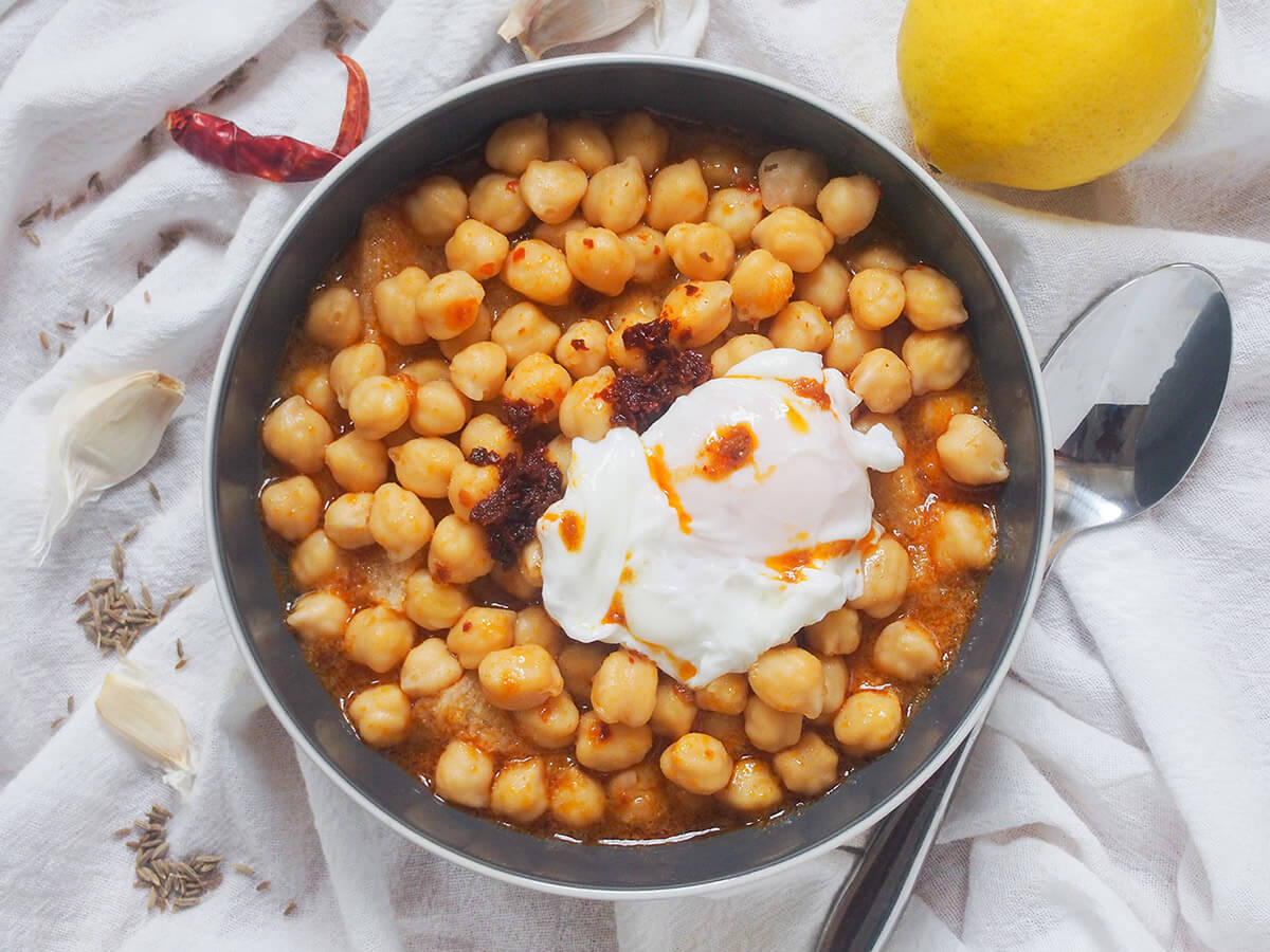 Lablabi has only a few ingredients, but the flavors are so vibrant you'd be forgiven for thinking otherwise. Filling from the chickpeas, with depth from the spices. Perfect on a cold day. bowl of lablabi with spoon to one side and spices to other, lemon above bowl