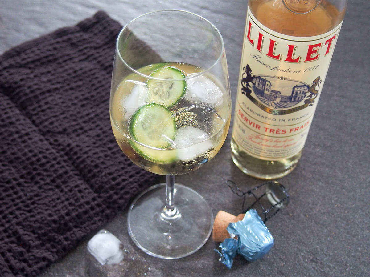 Everyone knows about THAT spritz, but this Lillet spritz is one to know as well. It's light and gently fruity, with just enough bubbles, plus incredibly easy too. Perfect for brunch or aperitivo hour. glass of lillet spritz with cucumber in glass and bottle of lillet to side and black cloth on other side
