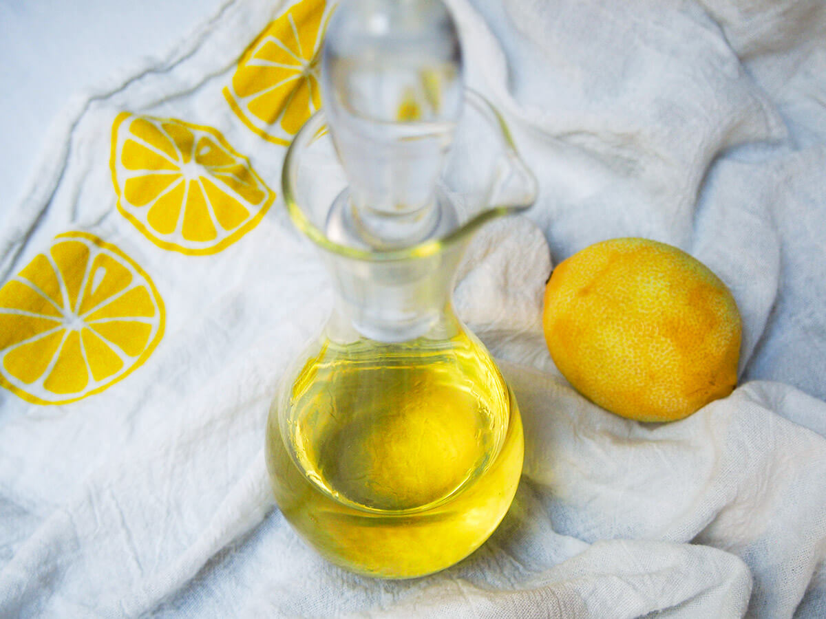 Homemade limoncello is easy to make and it's perfect as an after-dinner drink or used in cocktails. Plus great for gifting too. bottle of homemade limoncello with lemon to side