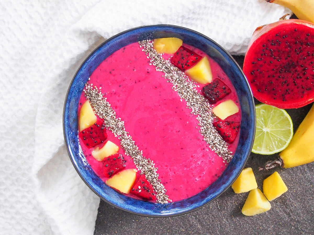 This mango and dragon fruit smoothie is so easy to make with deliciously fresh and tasty flavors. It's great as a snack, for breakfast or even dessert, especially as a smoothie bowl. mango dragon fruit smoothie with fruits to side