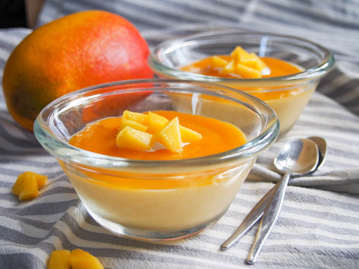 Mango panna cotta is a delicious fruity twist on the classic Italian creamy dessert. It's smooth and light with a wonderful flavor. The perfect make-ahead dessert! side view of dishes with mango panna cotta