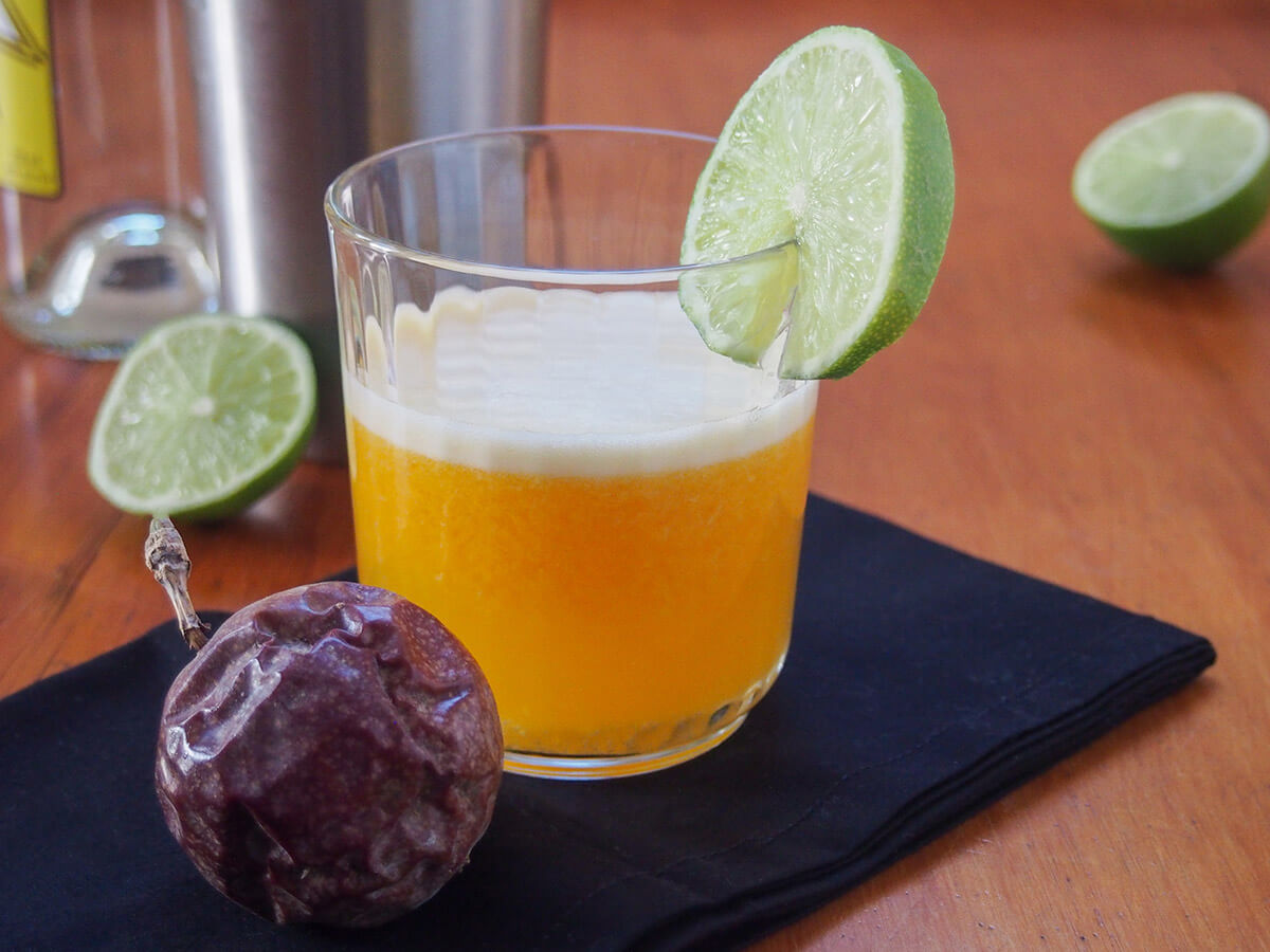 A maracuya sour is a wonderfully fruity twist on the Peruvian favorite, the pisco sour, with bright, fragrant passion fruit added into the mix. The result is a delicious combination of fruity, sweet-tart flavors that's refreshing with a pisco kick. glass of maracuya sour with part lime behind