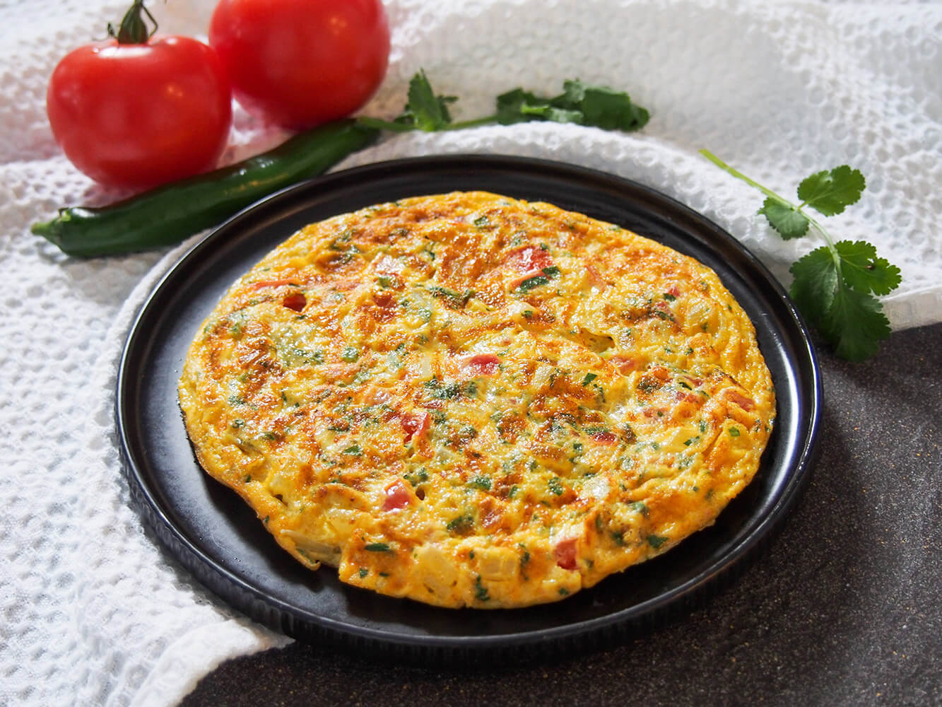 Masala omelette is a popular Indian breakfast and a great way to change up your usual omelette. It's quick to make, with a simple combination of vegetables and a bit of spice. masala omelette on plate