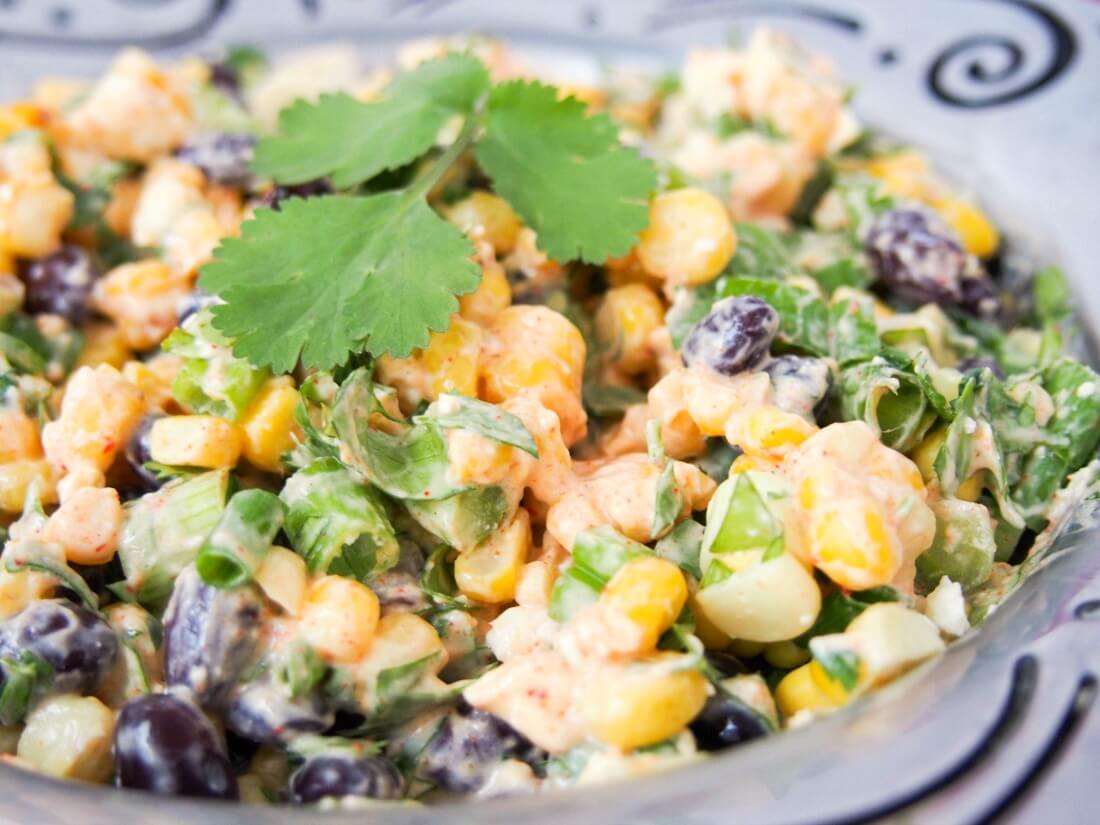 This Mexican street corn salad is easy to prepare and packed with delicious fresh flavors. With a healthier dressing, it makes a great side or potluck salad Mexican street corn salad in bowl from side