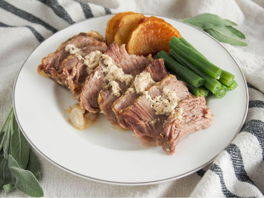 Maiale al latte is a traditional Italian milk-braised pork that's so comforting and delicious. The pork is incredibly tender and delicately flavorful. Plus it's easy to make too. Milk-braised pork (maiale al latte) on plate with green beans and potatoes as sides