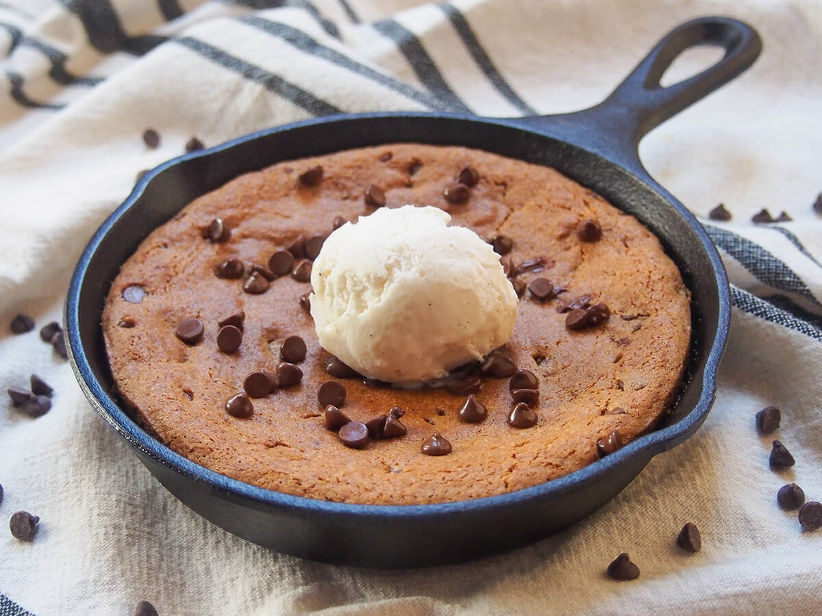 This mini skillet cookie is a so easy to make and a delicious mix of sweet, soft cookie studded with melty little bites of chocolate. It's gluten free, but you'd hardly notice. The perfect size for two to share, too. So tasty! mini skillet cookie topped with ice cream