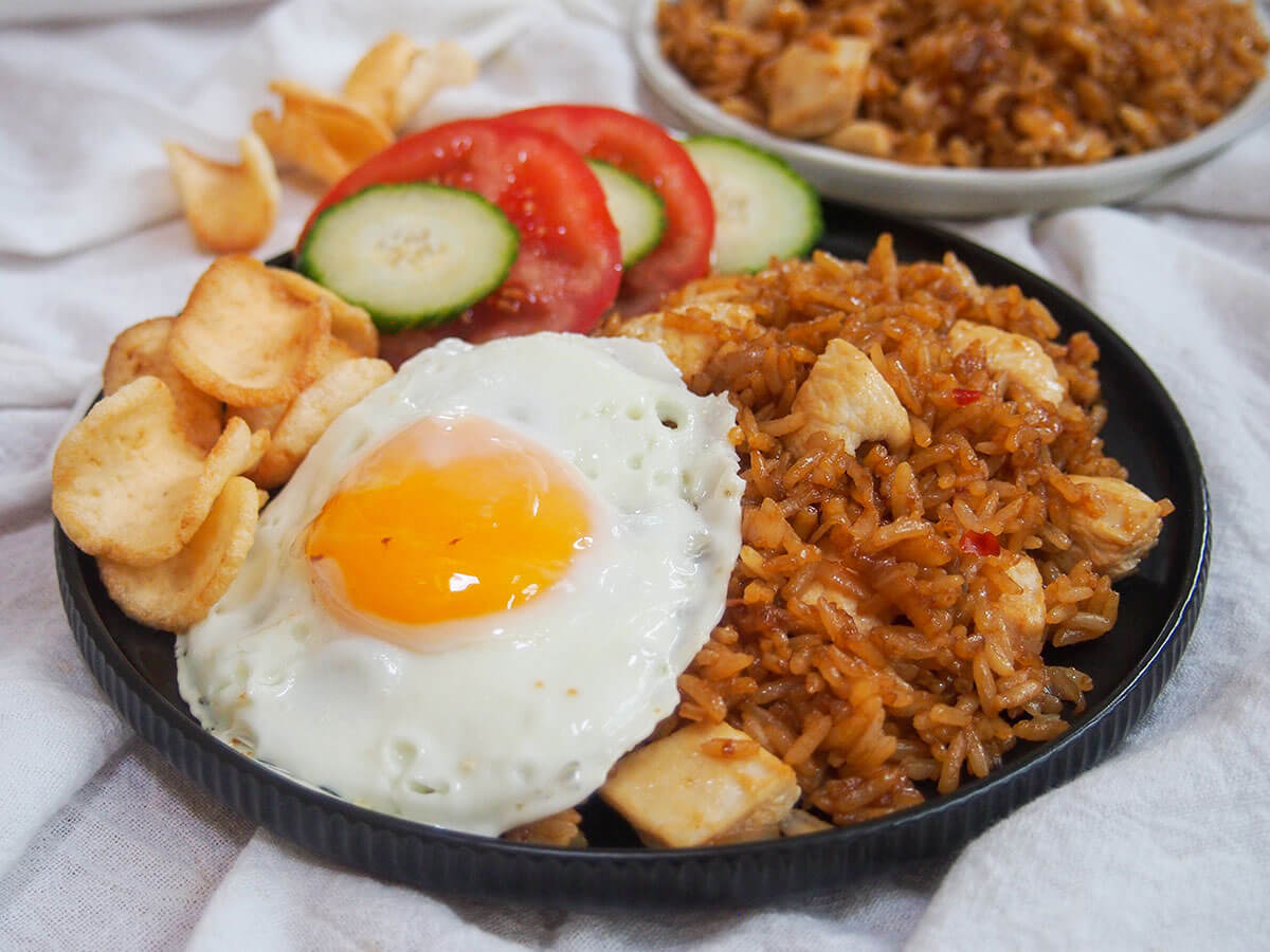 Nasi goreng is the Indonesian version of fried rice that has a wonderful mix of flavors including sweet soy, chili and shallot. Quick to make and easy to adapt, it's a delicious, flavor-packed meal. plate of nasi goreng Indonesian fried rice with fried egg to one side