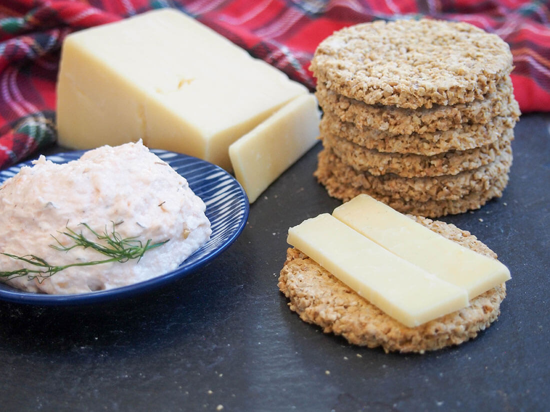 Oatcakes are a traditional Scottish cracker made with oatmeal. They're great with cheese, pate or on theirs own. Easy, tasty and healthy, too. stack of oatcakes to one side with block of cheese and dish with pate to other side