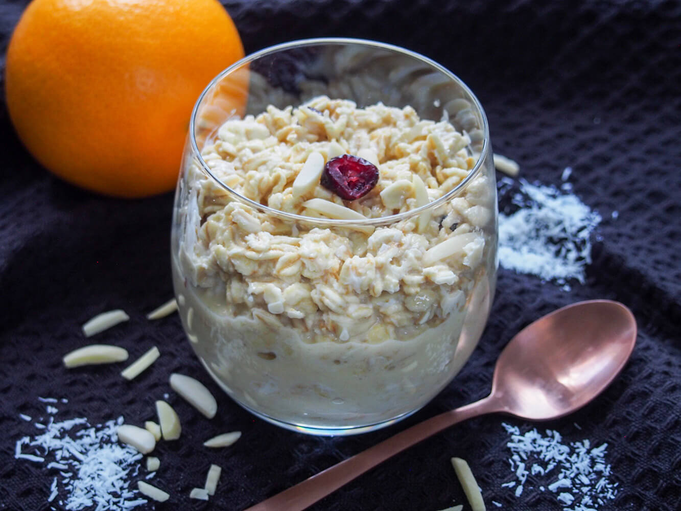 These orange overnight oats take just a minute to prepare the night before & in the morning for an easy, delicious and healthy citrusy and nutty breakfast. glass of orange overnight oats with spoon in front