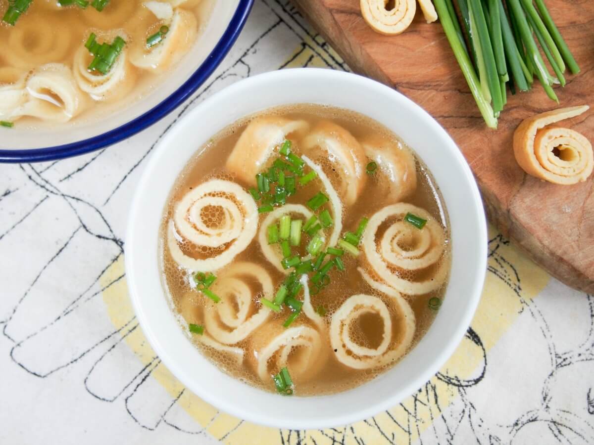 German pancake soup (Flädlesuppe) is a simple combination of broth with pancake 'noodles' that's tasty, comforting and a great cold-buster! bowl of German pancake soup viewed form overhead with coils of pancake and chives to side