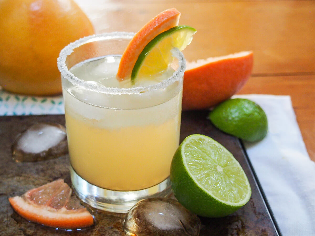 A Paloma cocktail - refreshing and so easy to make glass of paloma cocktail with half lime and grapefruit to side